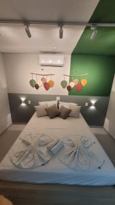 Flat Amarilis Apartamento 202 في ريفييرا دي ساو لورينسو: سرير كبير في غرفة بجدار أخضر