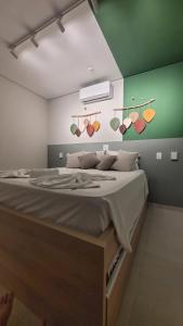 a bedroom with a large bed with a green wall at Flat Amarilis Apartamento 202 in Riviera de São Lourenço