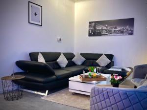 a living room with a black couch and a table at G&G Luxury Apartment am Stadtpark Bendorf in Bendorf