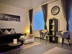 a living room with a couch and a clock on the wall at G&G Luxury Apartment am Stadtpark Bendorf in Bendorf