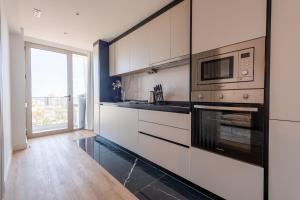 a kitchen with white cabinets and a microwave at The King Apartment in Santo António