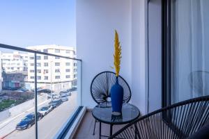 un jarrón azul sentado en una mesa en un balcón en Luxoria by ShortStayMaroc, Studio Moderne et Chic, Parking, Quartier Central, en Casablanca