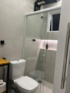 La salle de bains est pourvue de toilettes et d'une douche en verre. dans l'établissement Casa do Coité, à Rio de Janeiro