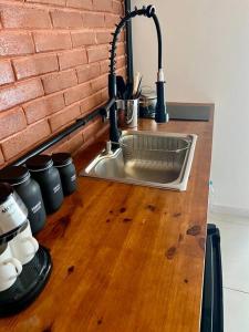 Casa do Coité في ريو دي جانيرو: طاولة مطبخ مع حوض وجدار من الطوب