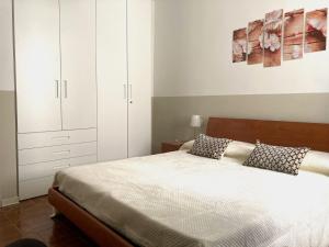 a bedroom with a large bed with white cabinets at Pae veciu casa vacanze in Monterosso al Mare