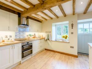 uma cozinha com armários brancos e uma janela em 3 Bed in Gwynfryn 83938 em Coedpoeth