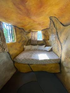 a room with a bed in a rock wall at Caverna El Mirador - La Mesa in La Mesa