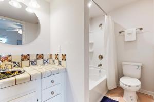 Un baño con inodoro, lavabo y espejo. en Rockport Getaway #608, en Rockport 15 fotos más