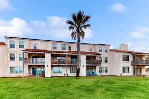 um edifício de apartamentos com uma palmeira em frente em Rockport Getaway #608 em Rockport