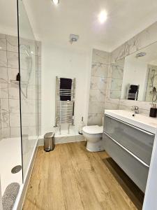 y baño con aseo, lavabo y ducha. en Kiwi Tree Serviced Apartment, en Cambridge