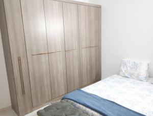 a bedroom with a large wooden cabinet next to a bed at Casa aconchegante in Cascavel