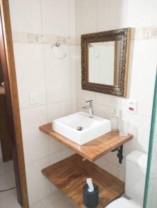 a bathroom with a sink and a mirror and a toilet at Casa aconchegante in Cascavel