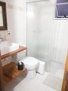 a bathroom with a toilet and a shower and a sink at Casa aconchegante in Cascavel