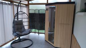 a black chair sitting in a room with a balcony at Gîte 4 étoiles La Belle Eau Calme in Futeau
