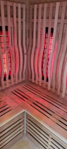 un banco de madera en una habitación con luces rojas en Gîte 4 étoiles La Belle Eau Calme, en Futeau