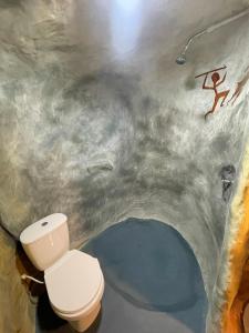 a bathroom with a toilet in a room with graffiti at Caverna El Mirador - La Mesa in La Mesa