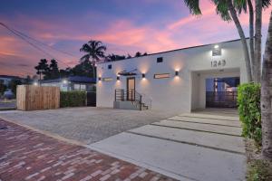 una casa blanca con una palmera delante de ella en Villa 1, en Miami