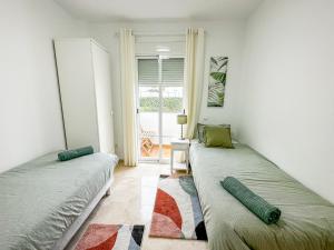 twee bedden in een kamer met een raam bij Small Oasis #3 in Manilva