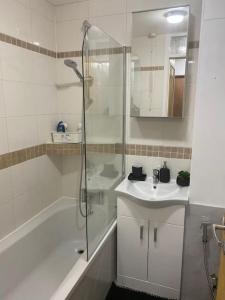 a white bathroom with a shower and a sink at Cozy flat in Birmingham with Parking in Birmingham
