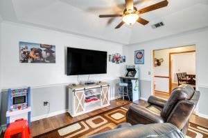 a living room with a couch and a flat screen tv at Beautiful Hinesville Retreat with Lanai and Pool! in Hinesville