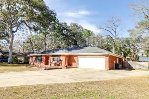 a brick house with a white garage at Beautiful Hinesville Retreat with Lanai and Pool! in Hinesville