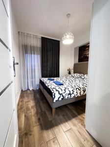 a bedroom with a bed and a large window at SIENNA GROBLA 6D/101 APARTAMENTY ZRESETUJ SIE W GDAŃSKU in Gdańsk