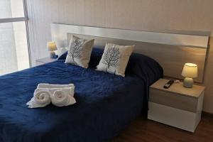 1 dormitorio con 1 cama azul y 2 toallas en Comodidad y vista impresionante, en Lima