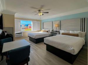 ein Hotelzimmer mit 2 Betten und einem Tisch in der Unterkunft Best Western Tradewinds in Morro Bay