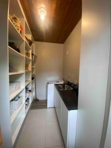 a small kitchen with a sink and a refrigerator at Casa de praia aconchegante in Barra Velha