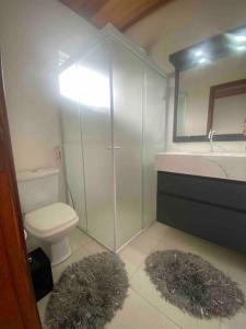 a bathroom with a toilet and a sink and a mirror at Casa de praia aconchegante in Barra Velha