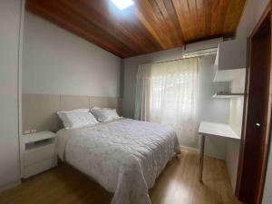 a small bedroom with a bed and a window at Casa de praia aconchegante in Barra Velha