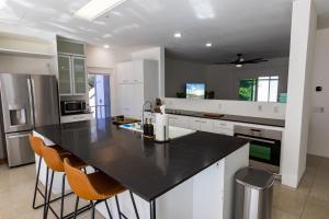 a kitchen with a black counter top and white cabinets at Elite Retreat! Hot Tub, Arcade, & Theater. 6 Beds! in Encinitas +44 photos