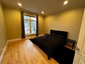 1 dormitorio con cama y ventana grande en Cozy Highland Park Home en Highland Park