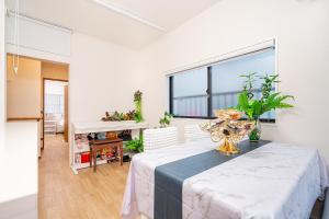 Una sala de estar con una mesa y una gran ventana. en 春5GWifi TokyoDome皇居1km〜 RoofGarden 上野秋葉原銀座東京2km～都心, en Tokio