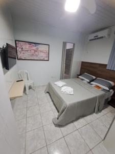 a bedroom with a large bed in a white room at Aconchegante Apto de 1qt a 60mts do Consulado EUA in Recife