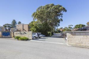 uma rua com carros estacionados num parque de estacionamento em Cottesloe Tree Top Studio em Perth
