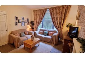 a living room with a couch and a table at Entire, main door, pet friendly, home away from home, East Ayrshire in Newmilns