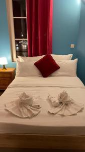a bed with white sheets and pillows and a window at Hôtel Le Saint Quentin in Saint-Quentin