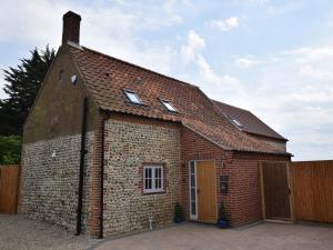 a red brick house with a brown roof at 3 Bed in Cromer 47832 in Northrepps