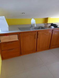 a kitchen with wooden cabinets and a sink at Close to Everything in Port-of-Spain