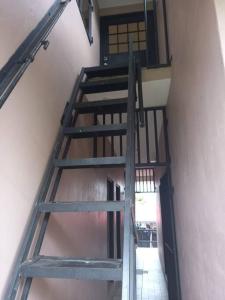 a wooden staircase leading up to a room at Close to Everything in Port-of-Spain