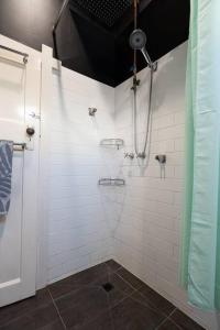 a bathroom with a shower with white tiles at Entire holiday house - Geelong - Sleeps 6 in Belmont