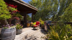 eine Holzterrasse mit einem Stuhl und Blumen in Fässern in der Unterkunft Summers House in Sonoma