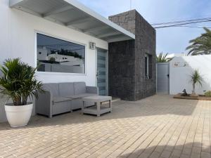 a patio with a couch and a table in front of a house at Villa Grey in Tahiche