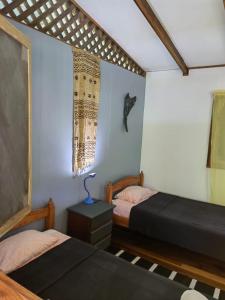 - une chambre avec deux lits et une lampe sur une table dans l'établissement Brisas del Caribe,Casa 2, à Puerto Viejo