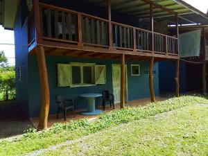 a house with a balcony and a table and chairs at Brisas del Caribe,Casa 2 in Puerto Viejo