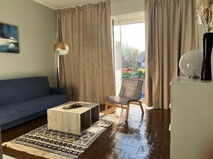 a living room with a blue couch and a table at Ady house 2 in Setúbal
