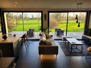 a living room with a couch and a table at Villa en bois à la campagne - 20 min de Rouen in Morgny-la-Pommeraye