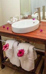 a bathroom sink with towels on a table with a sink at Starfish Tobago in Scarborough