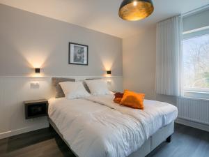 Dormitorio con cama con almohada naranja en Villa Col 38 en Kluisbergen